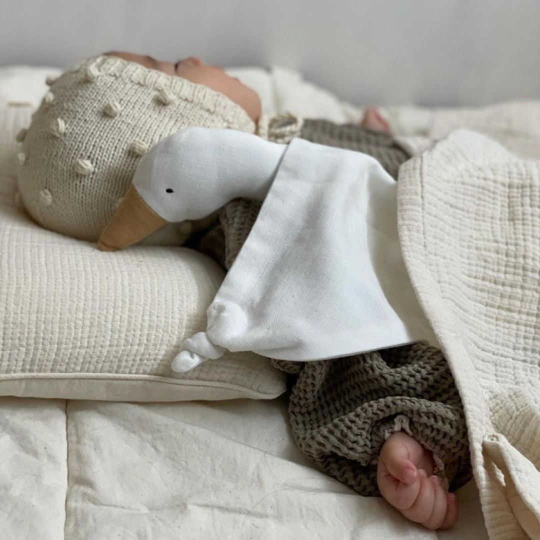 Bébé qui dort avec son doudou oie Saga Copenhagen en coton biologique
